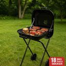 Black BBQ grill with food on a grassy outdoor setting